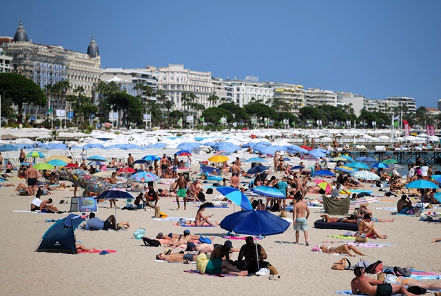 人们在法国戛纳海边消暑。新华社