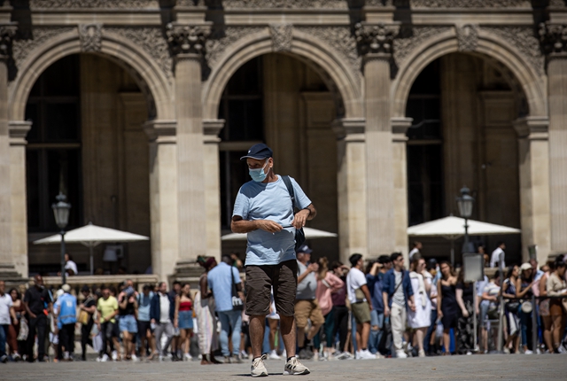 7月8日，一名佩戴口罩的男子走在法国巴黎卢浮宫广场。新华社